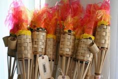 several bamboo sticks with orange and yellow ribbons on them are lined up next to each other