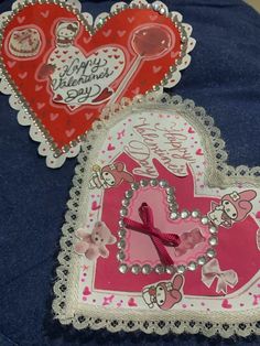 two heart shaped valentine's day greeting cards on a blue cloth covered tablecloth