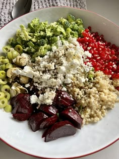 a white bowl filled with different types of food on top of a table next to utensils