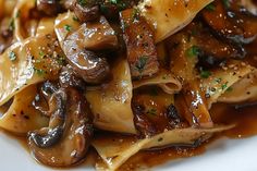 a white plate topped with pasta covered in mushrooms