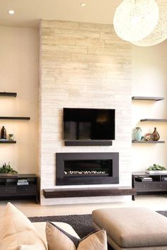 a living room with a couch, fireplace and television on the wall in front of it