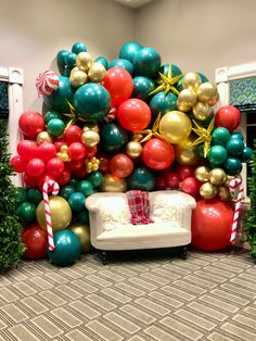 a room decorated for christmas with balloons and streamers on the wall, couch in foreground