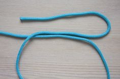 a close up of a blue rope on a wooden surface with one end connected to another