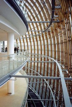 an escalator in the middle of a building with lots of glass and wood