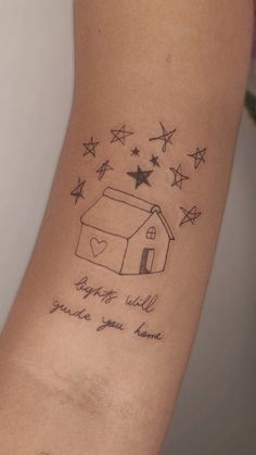 a small tattoo with stars and a house on it