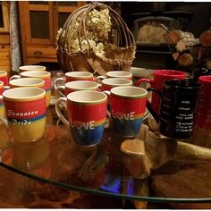 there are many coffee mugs on the table with their cups in front of them