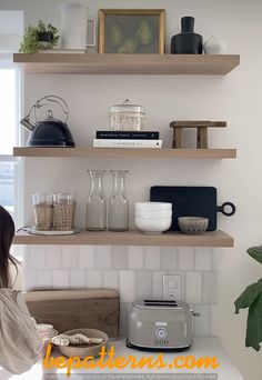 a woman is standing in front of some shelves with food on top of them and looking at the kitchen counter