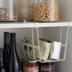 the shelves are filled with different types of food and beverages, including wine bottles and cereals