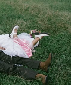 a bride and groom laying on the grass