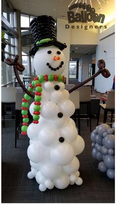 a snowman made out of balloons in the middle of a room with other decorations