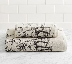 two black and white towels sitting on top of a marble counter