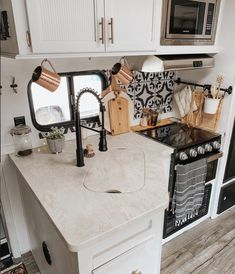 a kitchen area with a sink, stove and microwave in it's center island