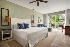 a bedroom with a large bed sitting next to a window filled with lots of windows