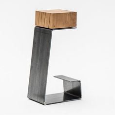 a small wooden object sitting on top of a metal stand