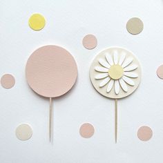 two cake toppers sitting next to each other on a white surface with polka dots