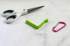 scissors, paper clips and clippings are sitting on a white table top with marbled surface