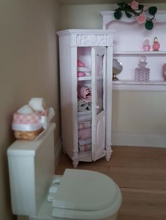 a doll house bathroom with toilet, sink and shelves