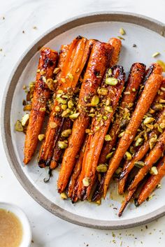 roasted carrots with pistachio seeds on a plate