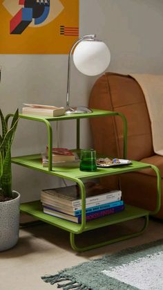 a green shelf sitting next to a couch in a living room with a lamp on top of it