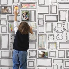 a young boy is drawing on the wall