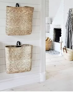 two baskets are hanging on the wall next to each other in a room with white walls and wood flooring