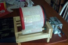 a red and white chair sitting on top of a wooden table next to a pile of books