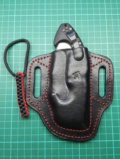 a black leather case with red stitching on it and a pair of scissors in the pocket