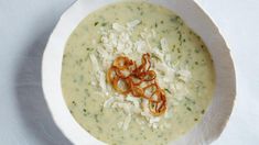 a white bowl filled with broccoli soup and garnished with croutons