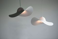 three lights hanging from the ceiling in a room with white walls and grey flooring