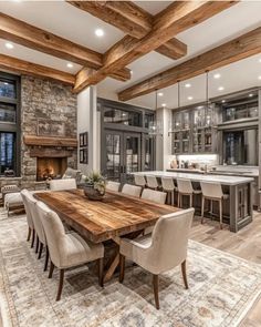 a large dining room table surrounded by chairs in front of an open kitchen and living area