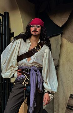 a man dressed in pirate costume posing for the camera