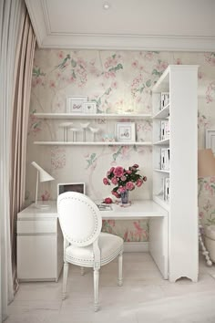 a white desk and chair in a room with floral wallpaper on the walls behind it