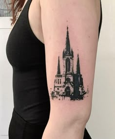 a woman's arm with a black and white ink drawing of a church on it