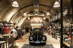 an antique car is parked in the middle of a shop