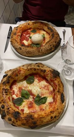 two pizzas sitting on top of white plates