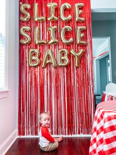 a baby sitting on the floor in front of a red and gold backdrop that says slice slice baby