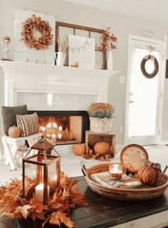 a living room decorated for fall with candles, pumpkins and other autumn decor items