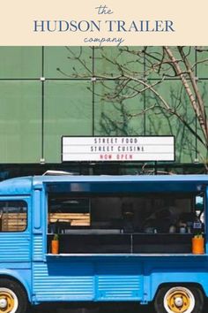 a blue food truck parked in front of a building with a sign that says the hudson trailer company