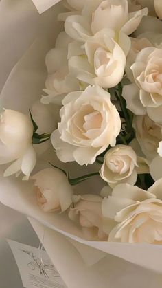 a bouquet of white roses in a paper wrapper