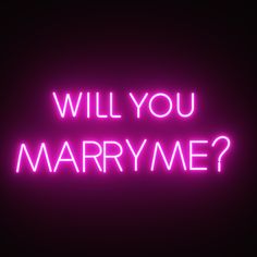 the words will you marry me? are lit up against a dark background with neon lights