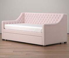 a white couch sitting on top of a hard wood floor