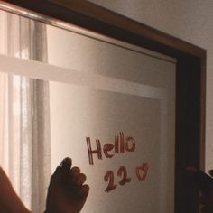 a person writing on a white board with red marker in front of them and the words hello 22 written on it