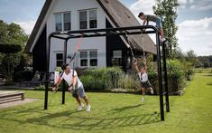 two men are playing baseball in front of a house