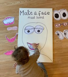 a toddler drawing on a poster with fake teeth