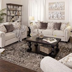 a living room with couches, chairs and rugs on the floor in front of windows