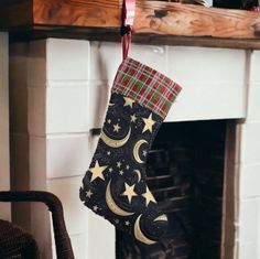 a christmas stocking hanging from a fireplace with stars and moon designs on the stockings