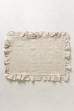 a white linen placemat with ruffled edges