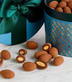 some nuts are sitting on a table next to a blue gift box