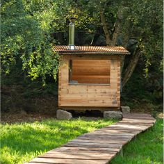 a small wooden outhouse sitting in the grass