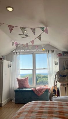 a bed room with a neatly made bed and a guitar on the window sill